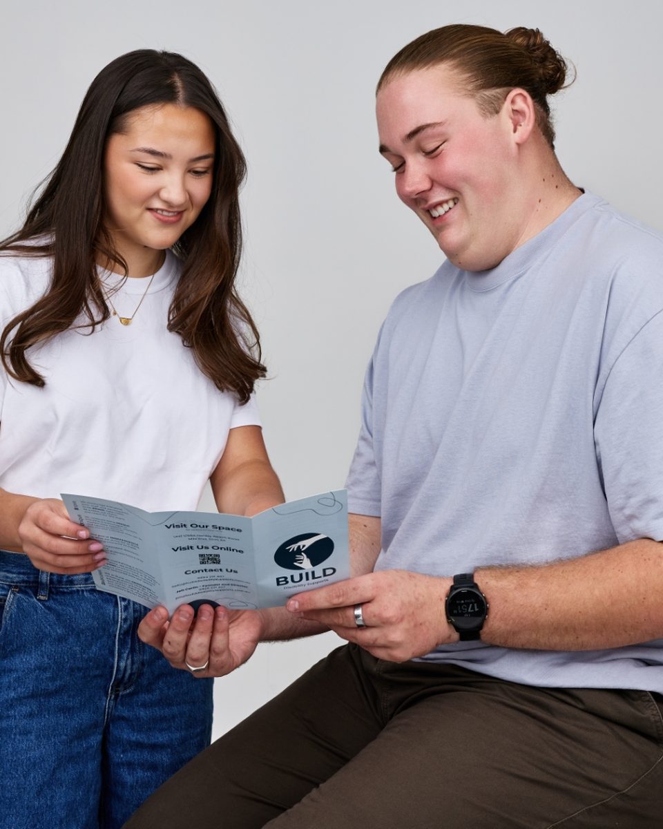 A Build participant drawing alongside their support worker